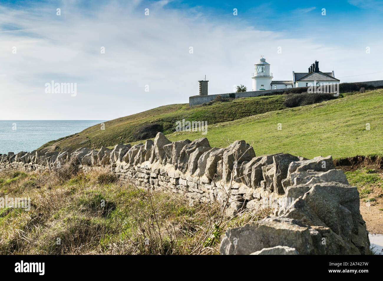 Amboss Point Lighthouse an einem sonnigen Tag mit Steinmauer auf der Jurassic Küste, Swanage, Dorset, England. Stockfoto