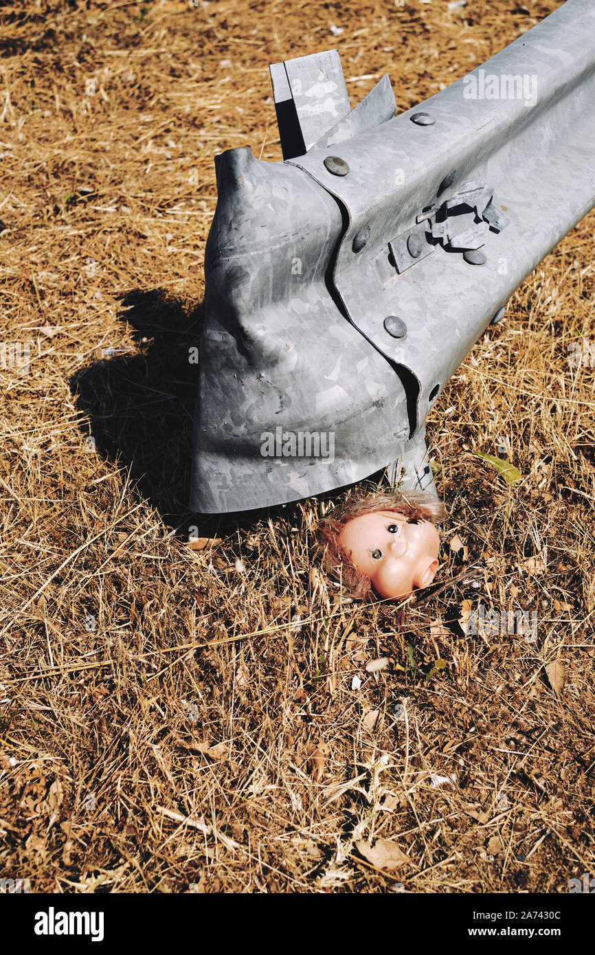 Verlieren Sie nicht den Kopf - fahren Sie sicher - ein verloren Puppen stehen am Straßenrand neben einer Metallstraße Barriere - skurrile gefährliche Straße fahren Warnung - Unfall Stockfoto