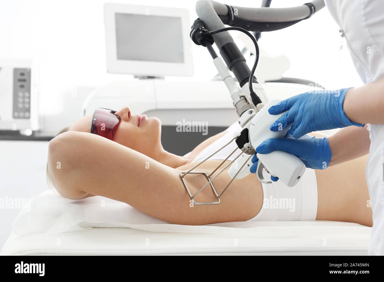Laser Haarentfernung unter die Arme. Frau in einem kosmetischen Klinik während Laser Haarentfernung Achseln Stockfoto