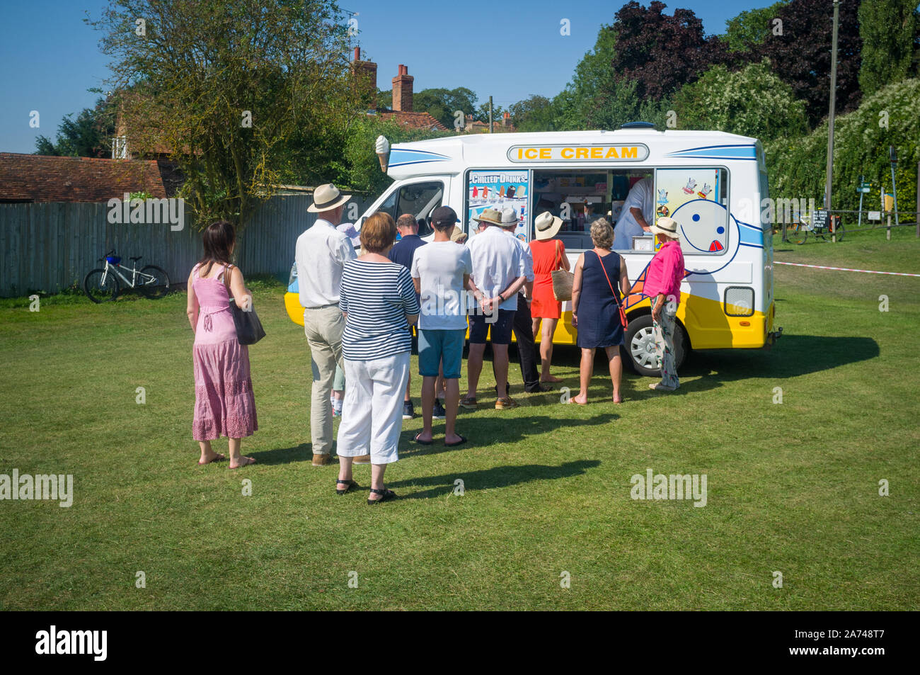 Menschen, die in einem traditionellen Sommerdorf-Fete in Ewelme, Oxfordshire, an einem Eiswagen für Eis Schlange stehen Stockfoto