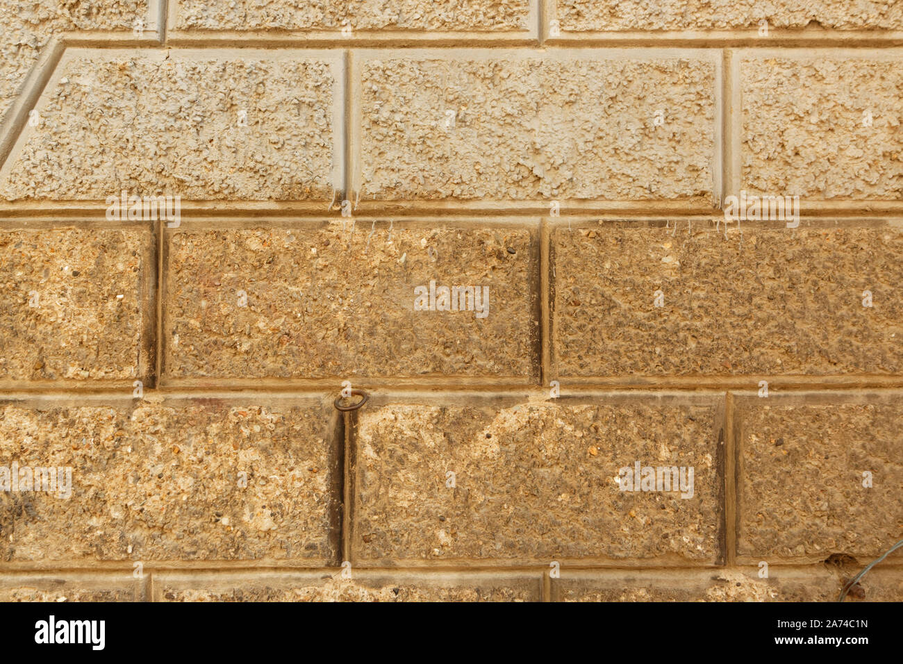 Stein mauer, die nicht einheitliche strukturierte Betonsteine mit flachen Schnitte. Stockfoto