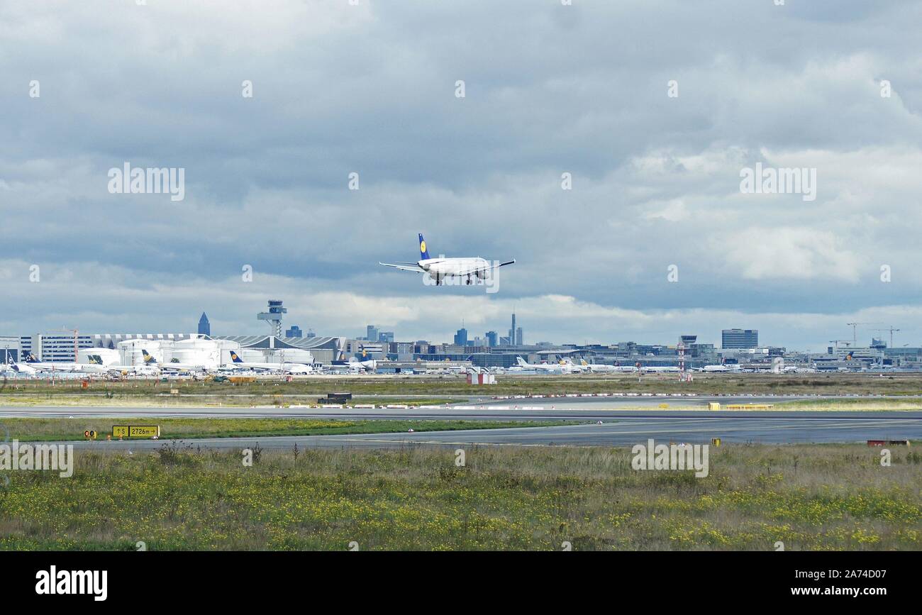 Flughafen Frankfurt. Teilweiser Blick von Westen des Flughafens Frankfurt am Main. Im Hintergrund kann man die Wolkenkratzer von Frankfurt. Ein Lufthansa Passagierflugzeug Airbus A321 landet auf der südlichen Start- und Landebahn. | Verwendung weltweit Stockfoto