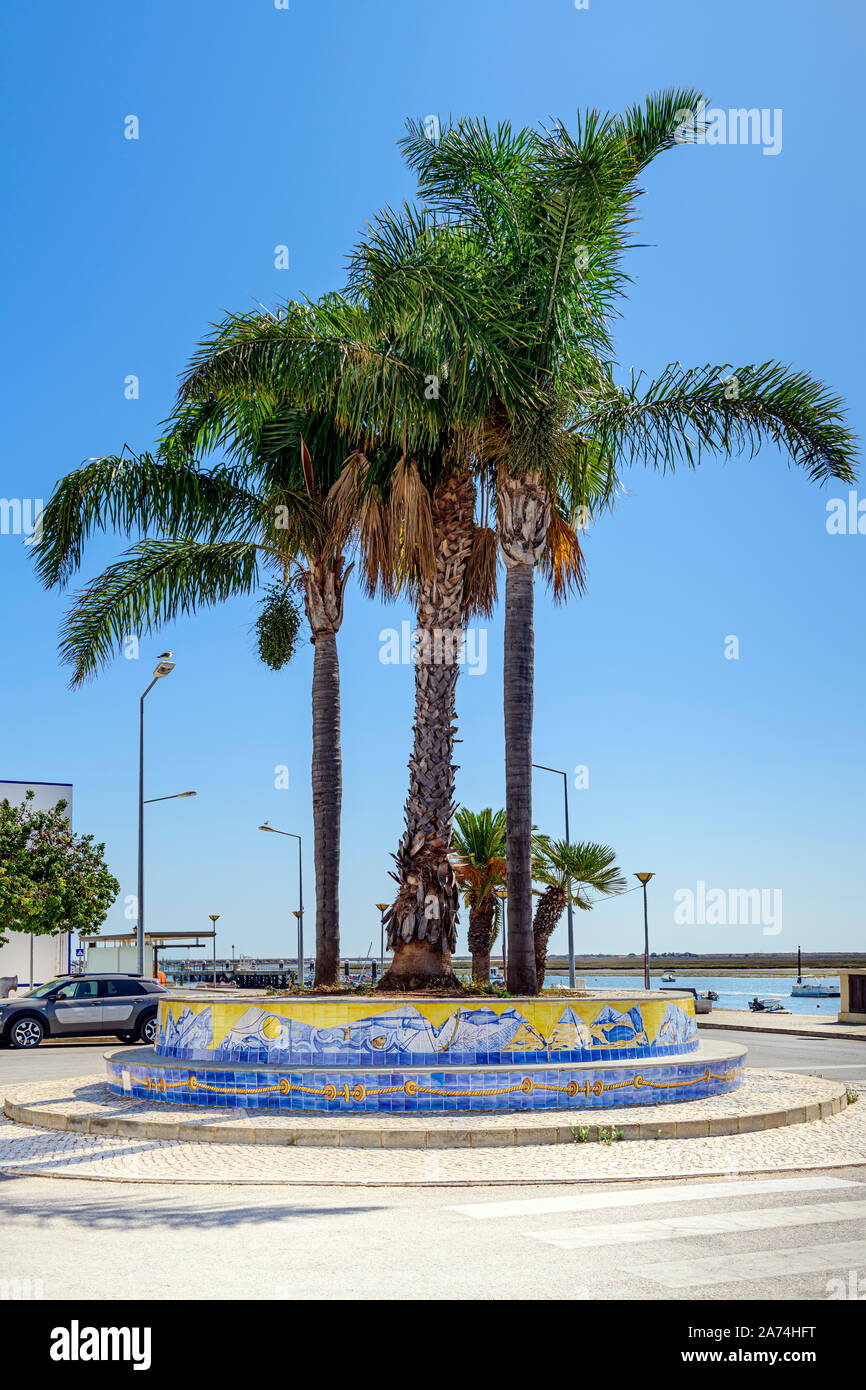 Palmen Palmen am Meer und Promenade in Santa Luzia gegen die Ria Formosa. Santa Luzia Algarve, Portugal. Stockfoto