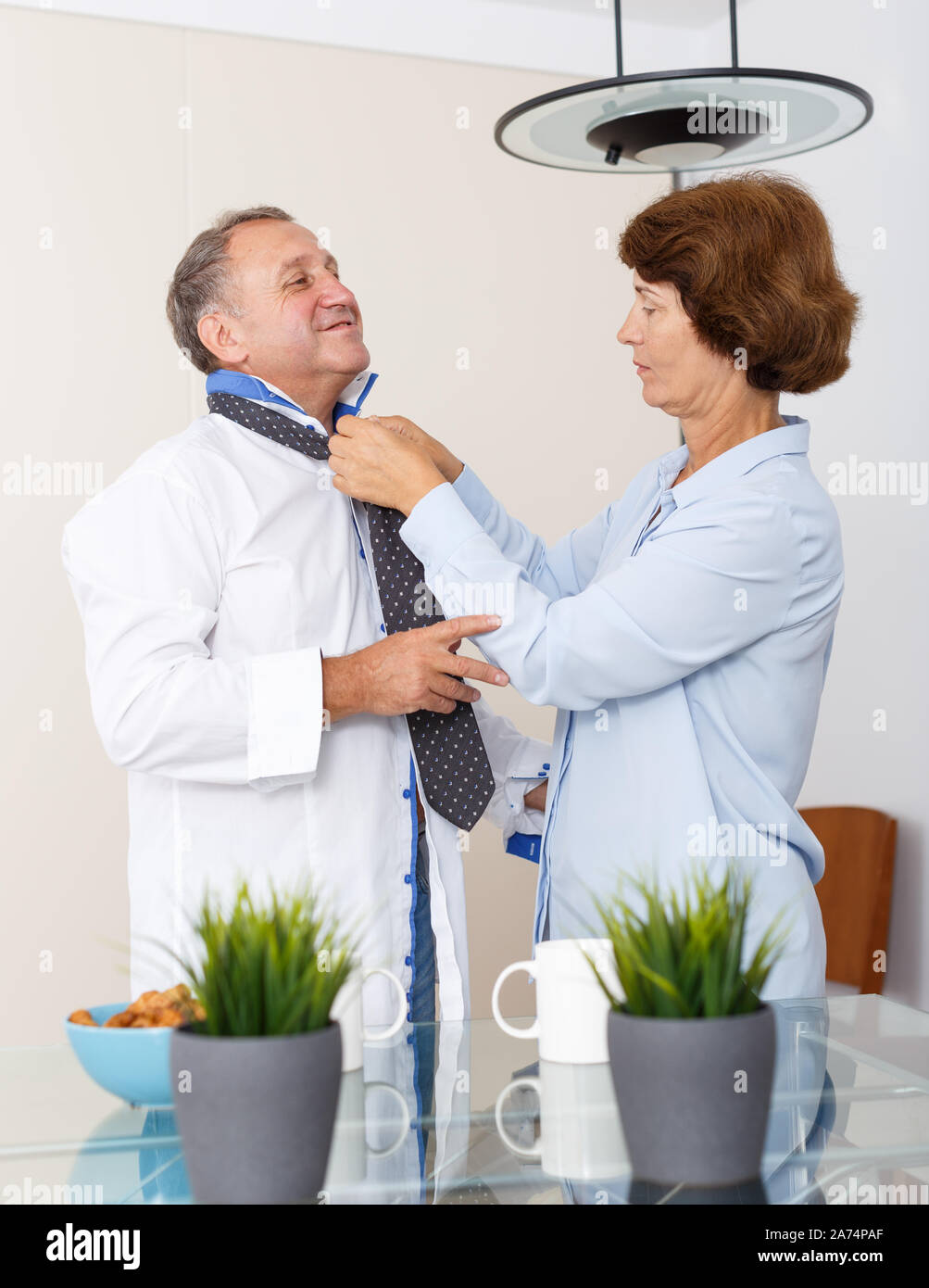 Portrait von positiven reife Frau zu Mann und Einstellen der Riegel zu Hause Stockfoto