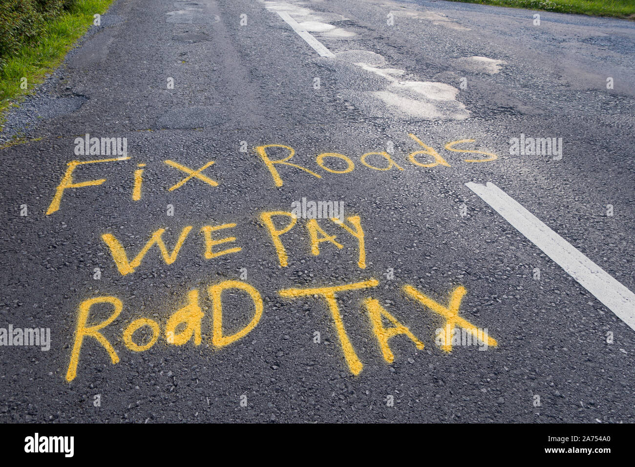 Protest zeichen Spray auf die Straße gemalt in Irland beschweren sich über die schlechte Instandhaltung der Straßen. Wir zahlen Straße Steuer Stockfoto