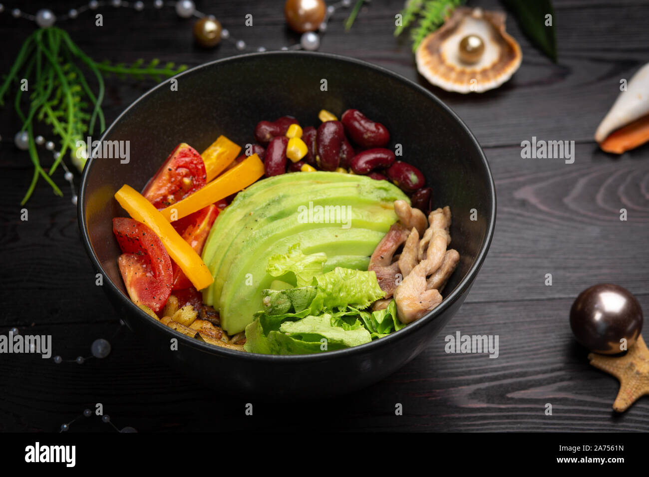 Huhn mit Gemüse in einer Schüssel schwarze Platte auf einem dunklen Hintergrund. Stockfoto