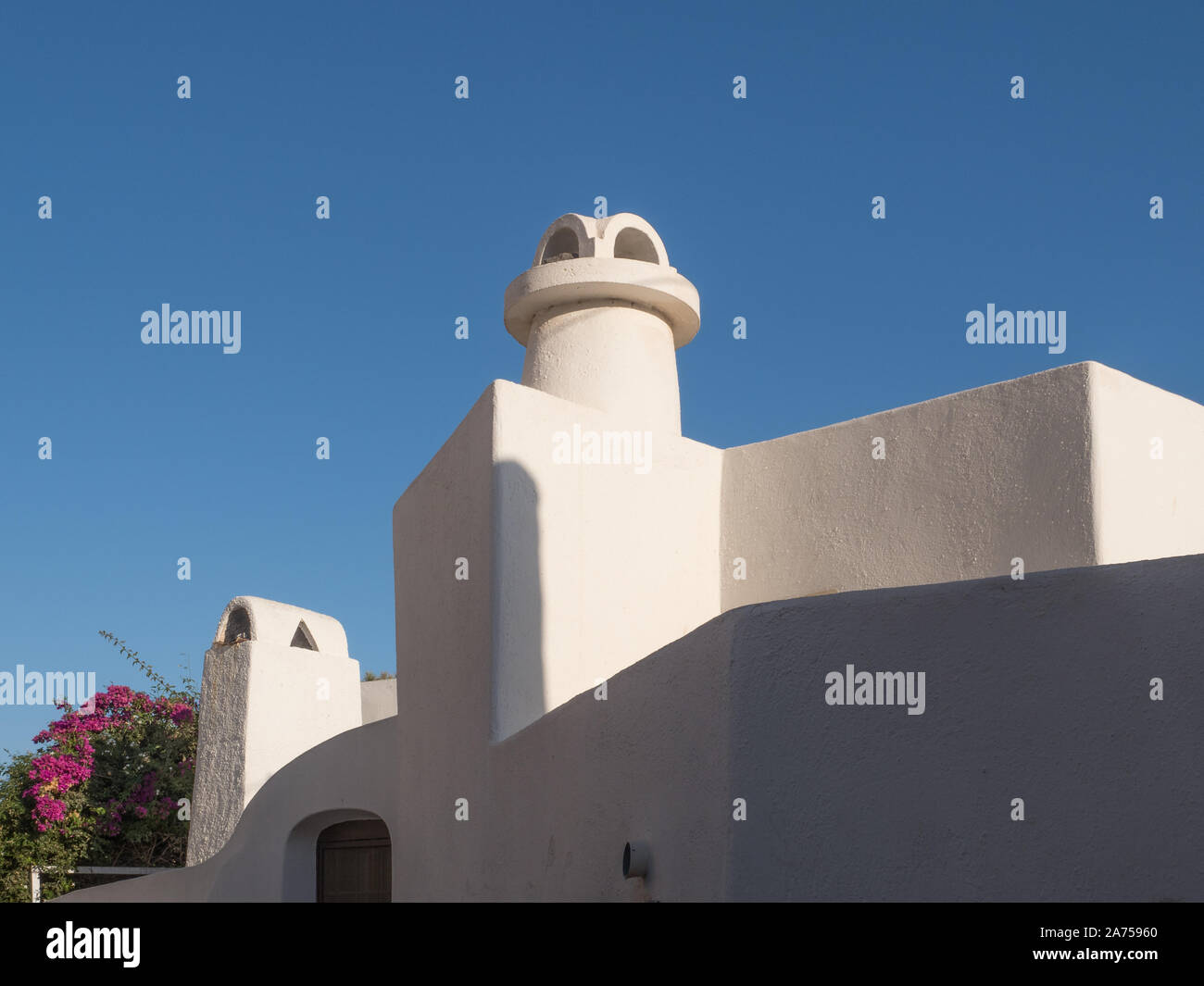 Ein Blick auf die Suche nach Form der Weißen chimney pot Außenkontur der Dachlinie gegen den blauen Himmel Santorini zu gestalten. Stockfoto