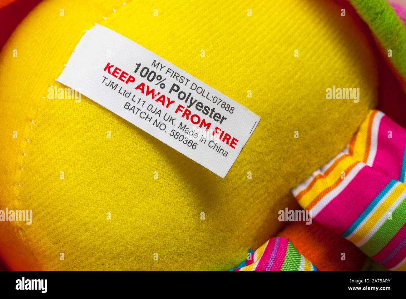 Vom Feuer fernhalten, 100% Polyester-Etikett auf meinem ersten Puppenspielzeug made in China Stockfoto