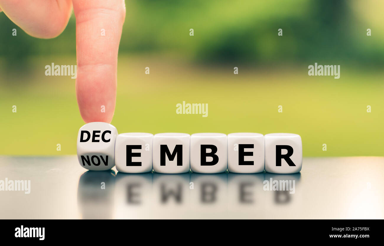 Symbol für die Änderung von November bis Dezember. Hand einen Würfel und Änderungen das Wort 'November' zu 'Dezember'. Stockfoto