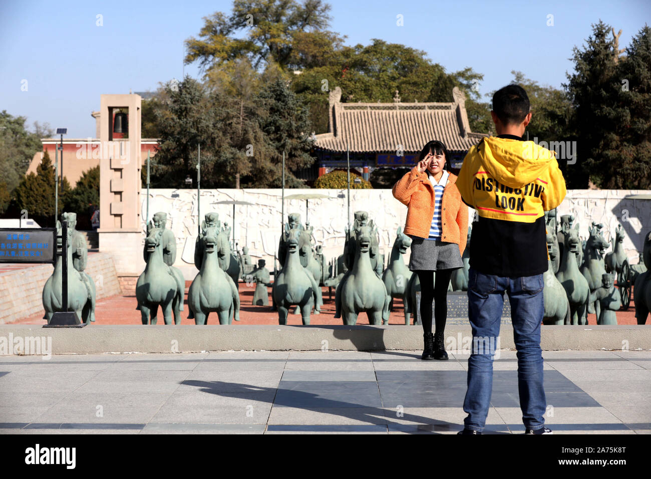 Wuwei, Provinz Gansu in China. 30 Okt, 2019. Touristen nehmen Fotos bei leitai Park in Wuwei Stadt im Nordwesten der chinesischen Provinz Gansu, Okt. 30, 2019. Wuwei ist die Heimat einer großen Anzahl von Bronze Artefakte, einschließlich der galoppierenden Pferd treten auf einem fliegenden Schwalbe, die ausgegraben wurde aus einem Grab der Östlichen Han-Dynastie (25 v. Chr. - 220 N.CHR.). Quelle: Guo Gang/Xinhua/Alamy leben Nachrichten Stockfoto