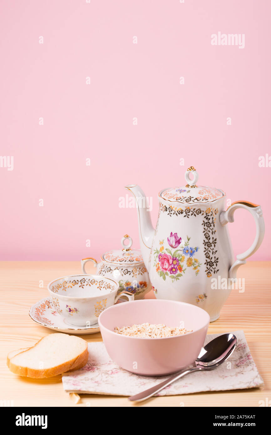 Haferflocken in einem rosa Platte und schöne Vintage Tee Utensilien Stockfoto