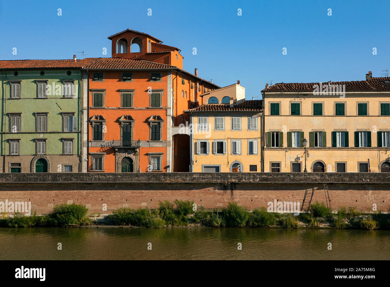 Bunten historischen Gebäuden, die von Arno. Traditionelle Häuser mit Fensterläden von Ufer in Pisa, Italien. Tag Sommer in der Toskana. Altstadt. Stockfoto