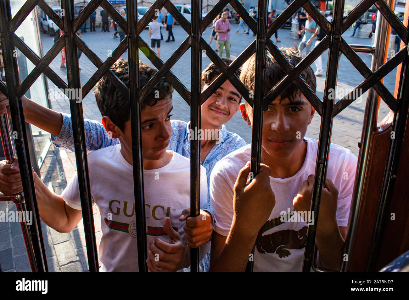 Istanbul: Türkische Jungen hängen an der historischen T2-Leitung Taksim-Tunel Straßenbahn aus dem Taksim Platz auf den Schienen der berühmten Avenue Istiklal Caddesi Stockfoto