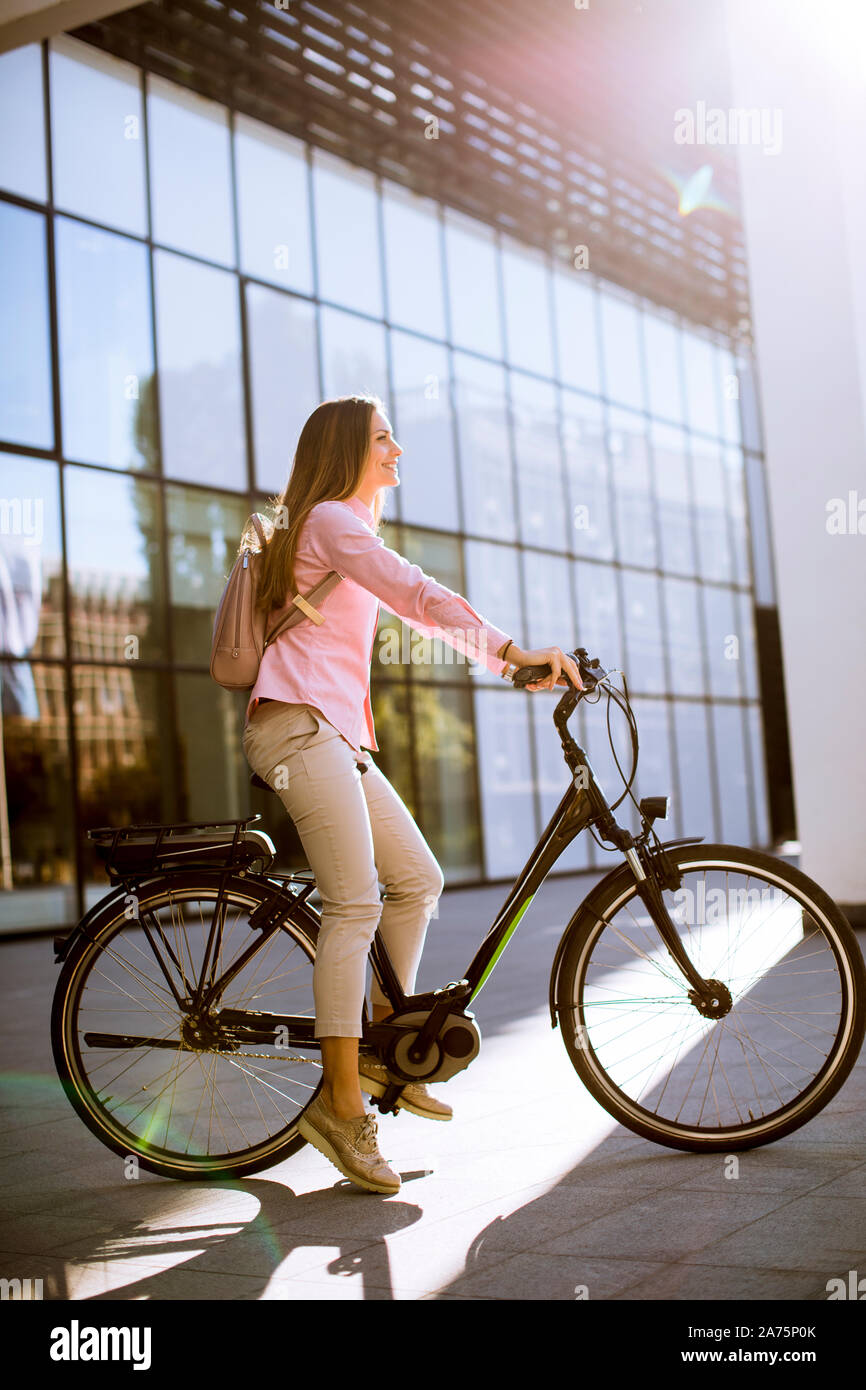 Junge Frau mit Tablet und e-Bike im Freien an einem sonnigen Tag Stockfoto