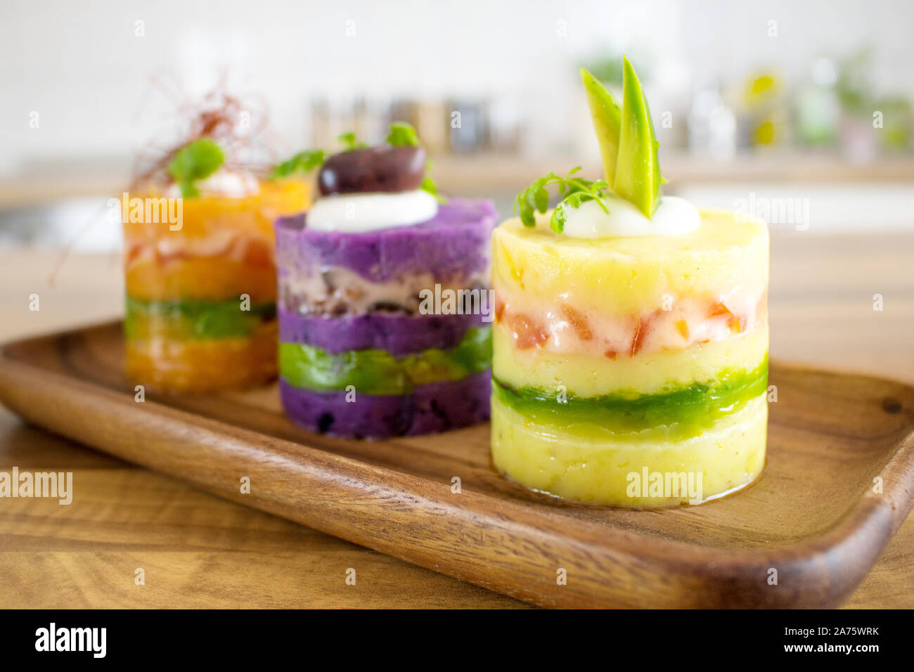 Essen Fotografie der peruanischen Gericht causa mit 3 Arten von farbigen Kartoffeln Stockfoto