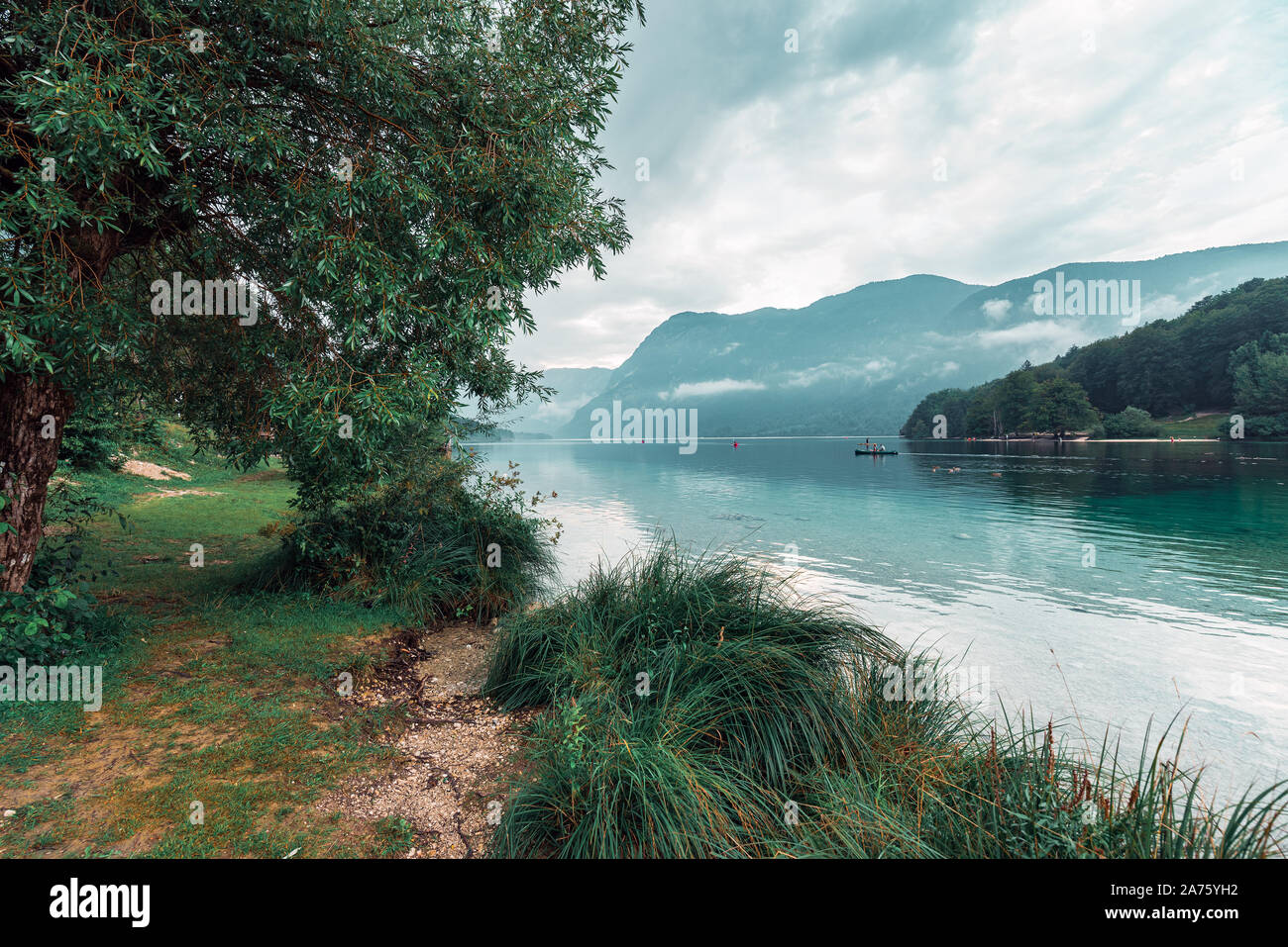 Bedeckt Nachmittag am See Bohinj, Slowenien. Personen, die im freien Wasser Sport bei schlechtem Wetter Stockfoto