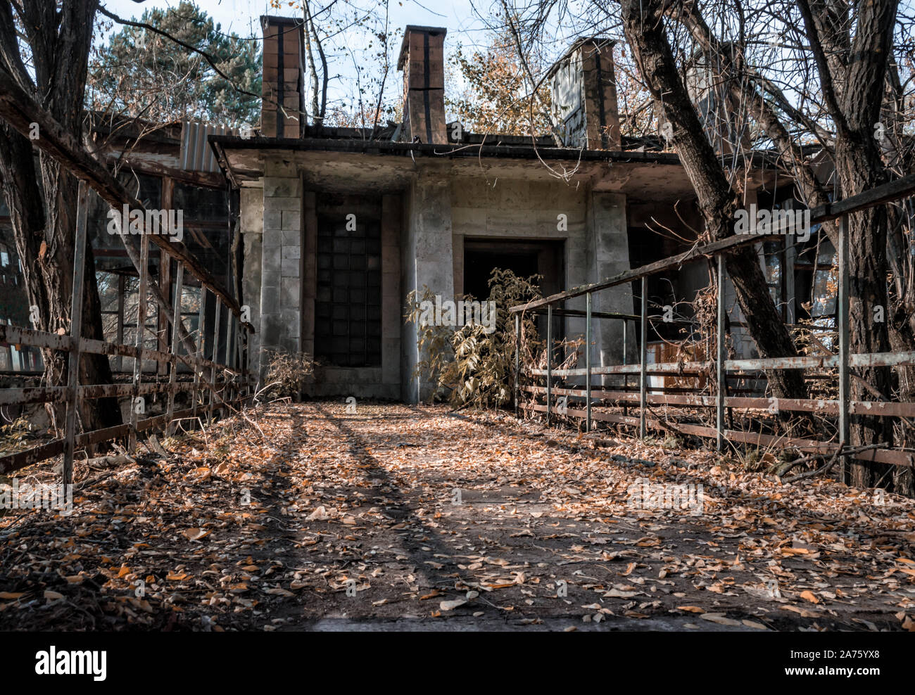 Verlassene Gebäude in einem infizierten Gebiet mit Bäumen in Tschernobyl in der Ukraine im Herbst Stockfoto