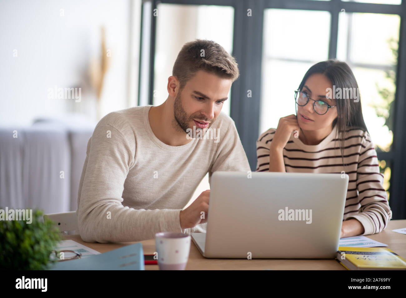 Frau Brille im Gespräch mit Ehemann während der Arbeiten von einem Remotestandort aus Stockfoto