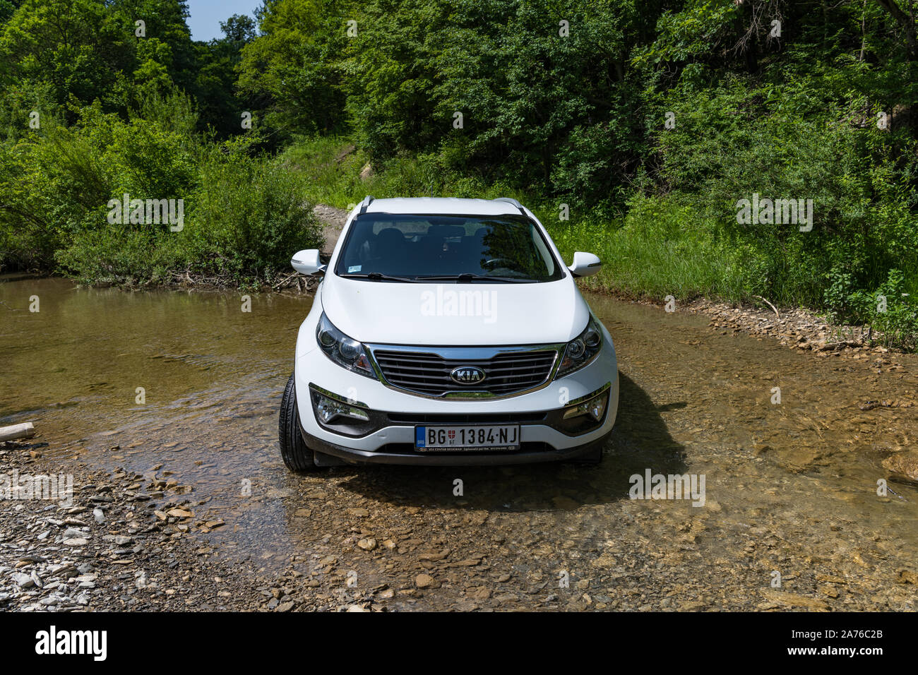 Kia Sportage awd oder 4x4, Farbe weiß, überquert den Bach (Calanques), mit einem sehr steilen und rutschigen Felsen unten. SUV-Auto in Wasser Stockfoto