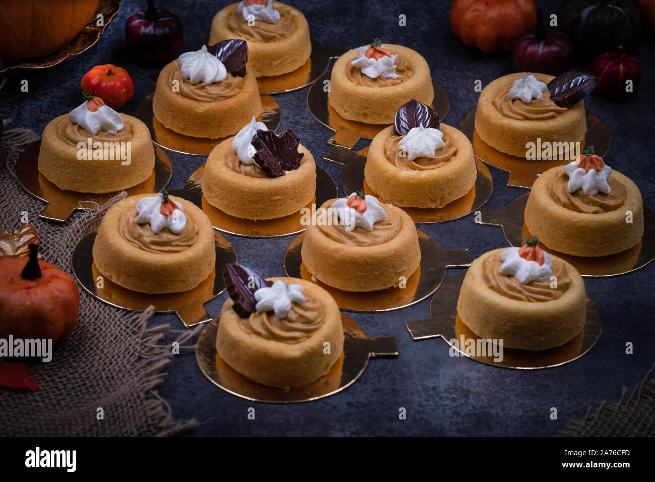 Kuchen Tanks mit Pumpkin spice Creme gefüllt, mit Schokolade Blätter und kleine Royal icing Kürbissen dekoriert Stockfoto