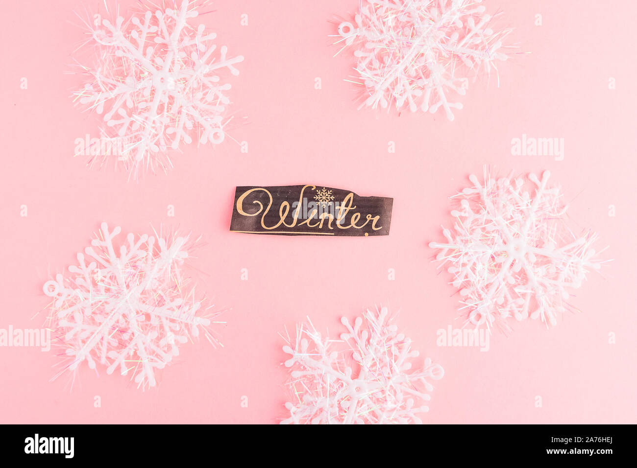 Schneeflocken auf einem rosa Hintergrund mit Winter Schriftzug Inschrift. Winterurlaub festliche Begrüßung gift card. Xmas flachbild Konzept legen. Stockfoto