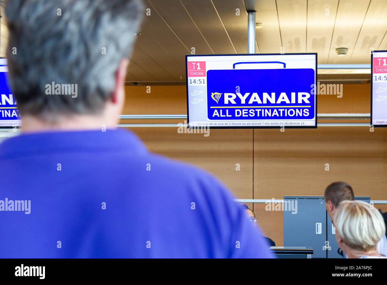 Passagiere warten an Ryanair Abfertigungsschalter am Flughafen von Charleroi. Stockfoto