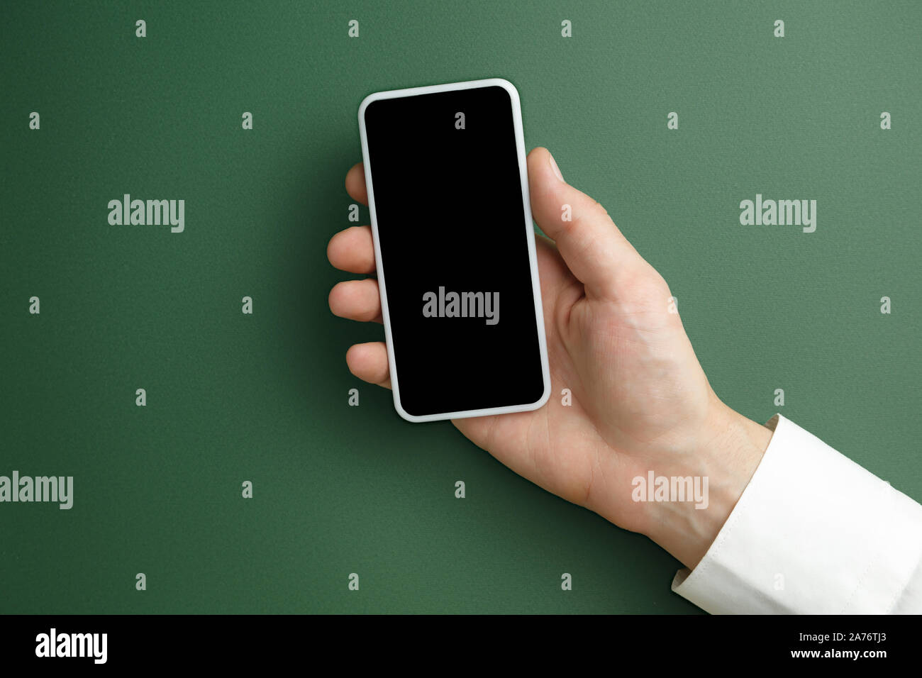 Männliche hand Smartphone mit leeren Bildschirm auf grünem Hintergrund für Text oder Design. Blank gadget Vorlagen für Kontakt oder den Einsatz in Unternehmen. Finanzen, Büro, Einkäufe. Mock up. Copyspace. Stockfoto