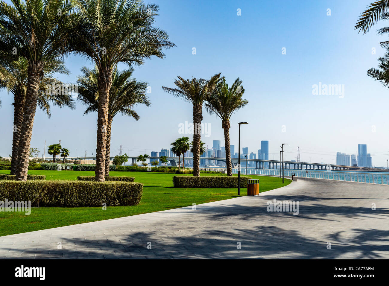 Blick auf das Datum Palmen Garten in der Nähe des Louvre Abu Dhabi Museum und das Abu Dhabi City Skyline im Hintergrund Stockfoto