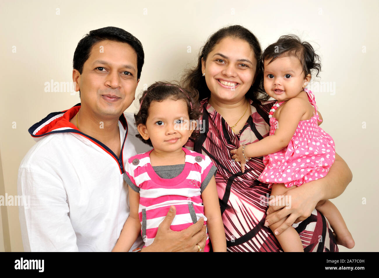 Mumbai, Maharashtra, Indien - Asien, Nov. 2011 - Indische glückliche Familie Eltern mit (4 Jahre und drei Monate) Zwei süße kleine Mädchen lächelnd. Stockfoto