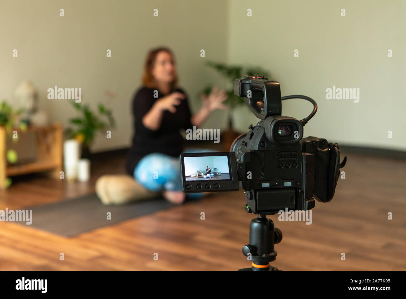 Selektiver Fokus Foto von Menschen nebeneinander mit ihren Waffen in einem Yoga Position beim Abhören der Yoga-lehrer im Hintergrund Stockfoto