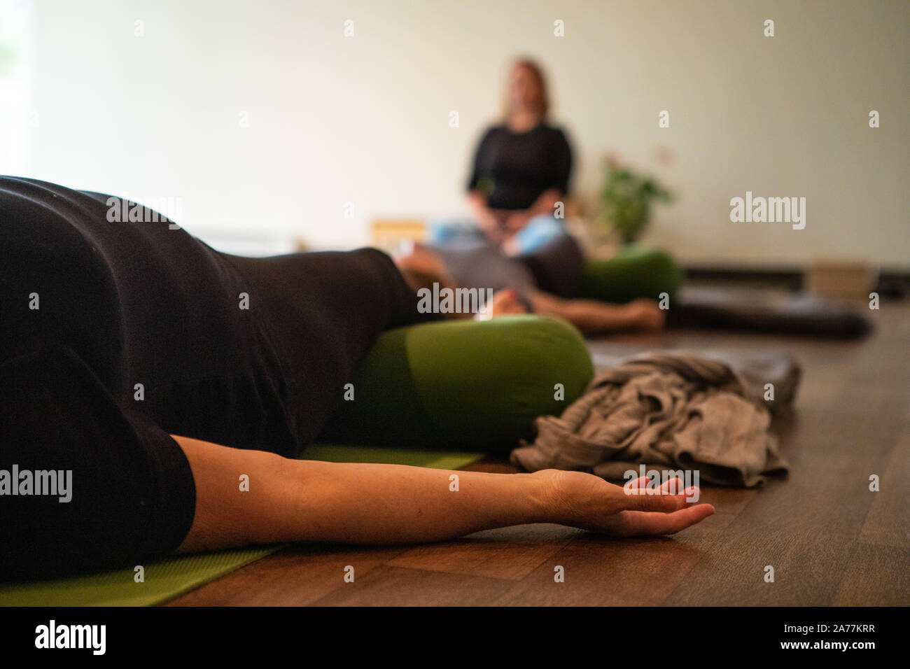 Selektiver Fokus Foto von einer Kamera Filmen eine professionelle Yoga Lehrer erklären, Positionen in einer Gruppe Yoga Stockfoto
