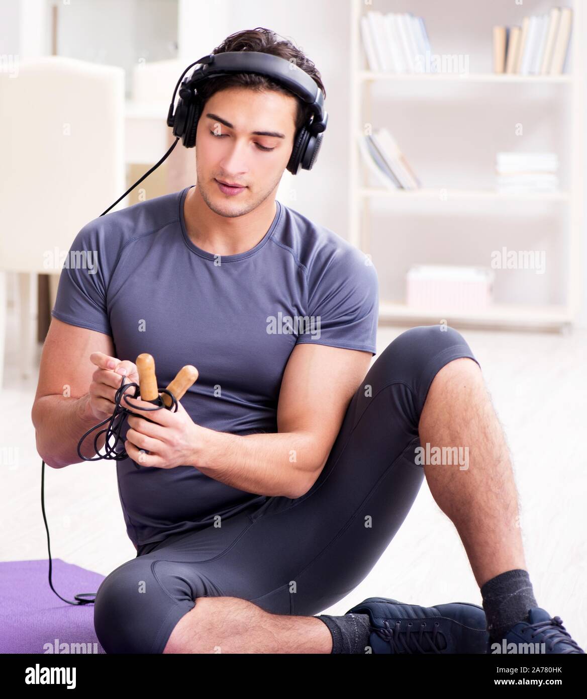 Der Mann sport zu hause und Hören von Musik Stockfoto