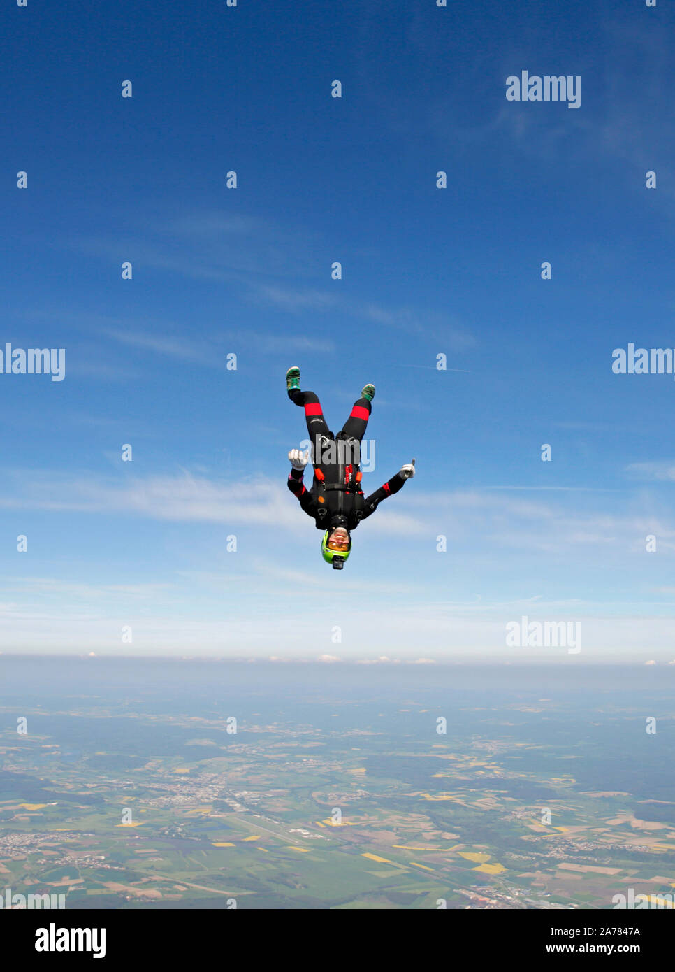 Dieser Spaß Jumper fliegen hoch in den Himmel und die Schulung der Kopf nach unten positionieren. Bald muss er seinen Fallschirm zu öffnen ein Fallschirmspringer zu speichern. Stockfoto