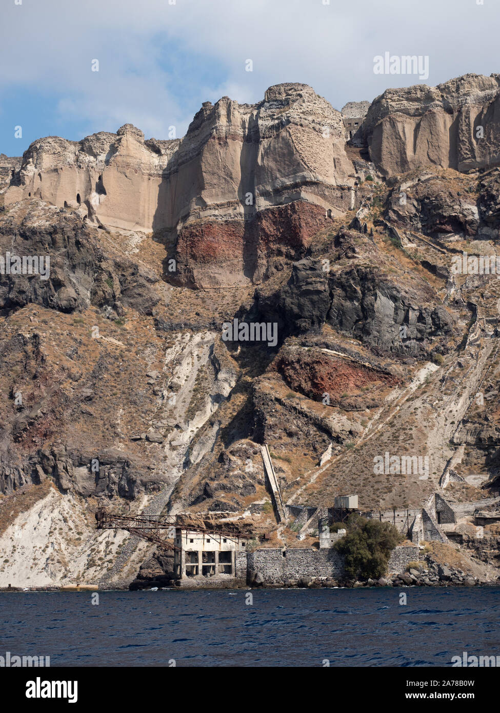 Ein Blick auf den stillgelegten Santorinis heruntergekommenen verlassenen, alten Bergbau Bergwerk station mit Förderband am unteren Rand der Klippe mit Lava Schichten Stockfoto