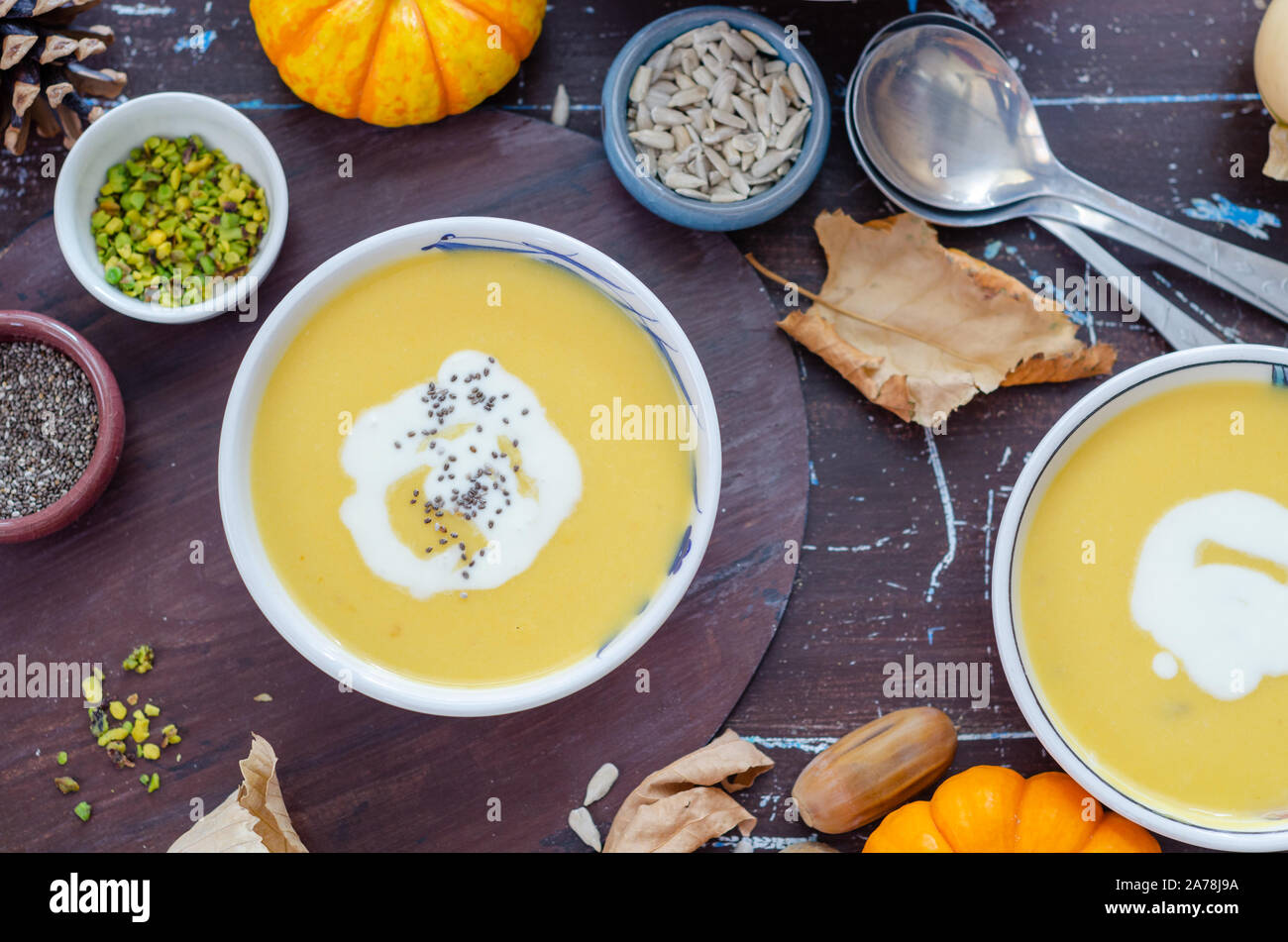 Kürbiscremesuppe mit Kürbiskernen auf braunen Tisch. Stockfoto