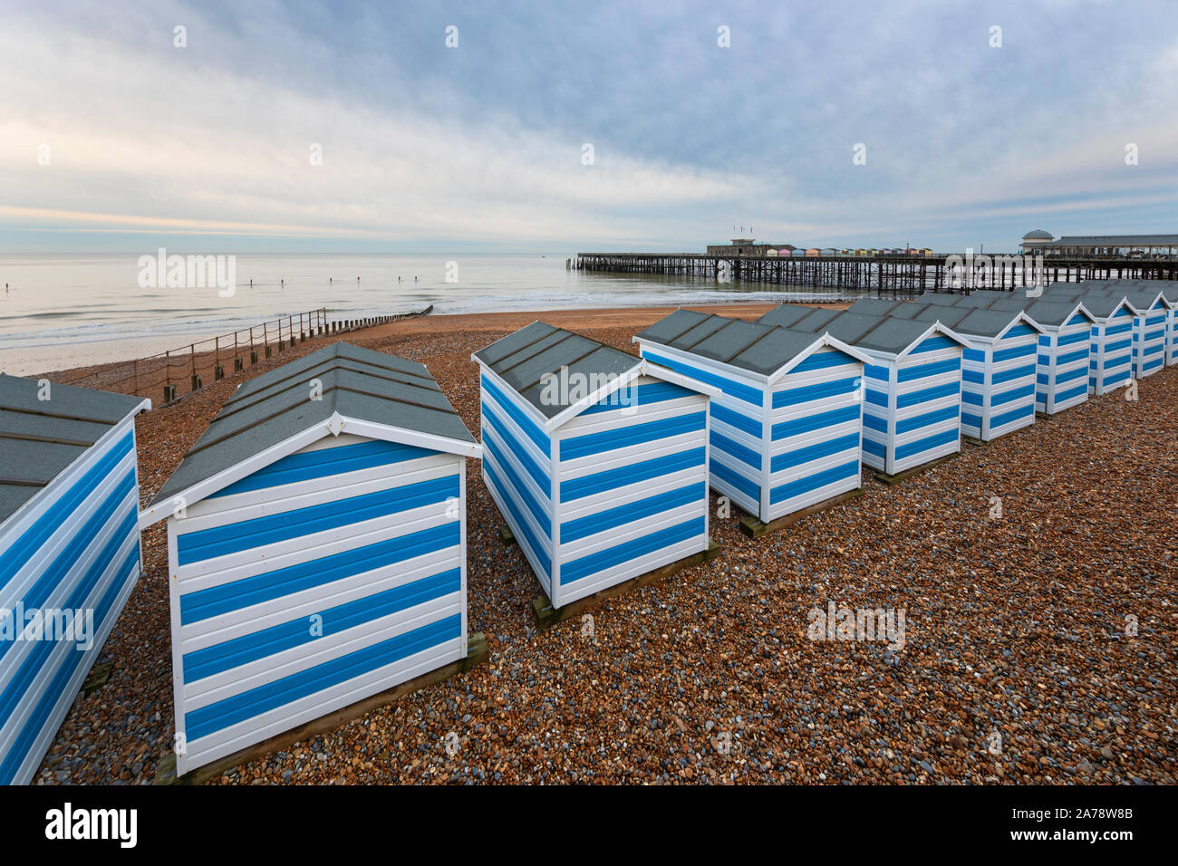 Strand Hütten am Kiesstrand mit Hastings Pier hinter im Morgengrauen, Hastings, East Sussex, England, Vereinigtes Königreich, Europa Stockfoto