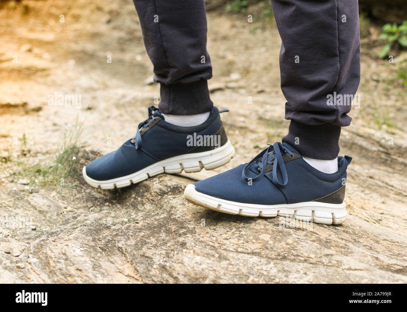 Mann in blauen Turnschuhe auf Asphalt bei Sonnenuntergang. Herrenschuhe. Stockfoto