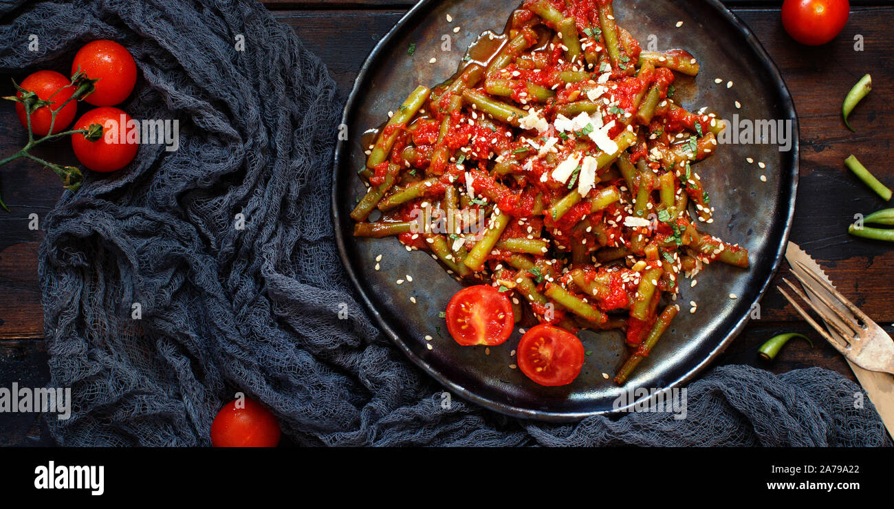 Bohnen mit Tomaten Eintopf Draufsicht auf einen dunklen Tisch Stockfoto