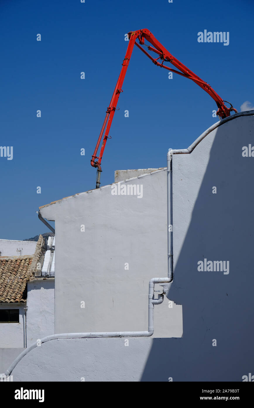Künstlerische Sicht auf eine Pumpmaschine aus rotem Beton während der Rennovation eines typischen weißen Hauses in einem kleinen Dorf in Andalucia. Southrn Spanien Stockfoto