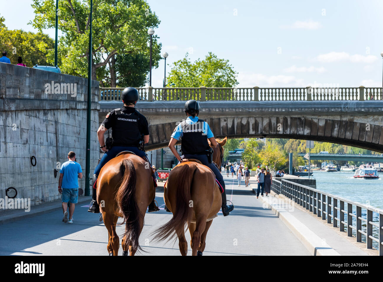 Zwei Polizisten auf Pferden patrouillieren durch den Gang des Flusses seine in der Innenstadt von Paris, Frankreich. Stockfoto