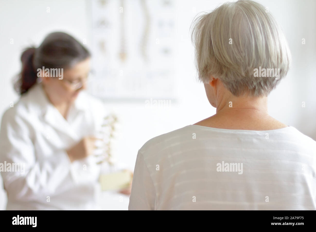 Altern und Rückenschmerzen Konzept: Ältere Patienten Beratung Ihr Arzt wegen Bandscheibenvorfall. Stockfoto