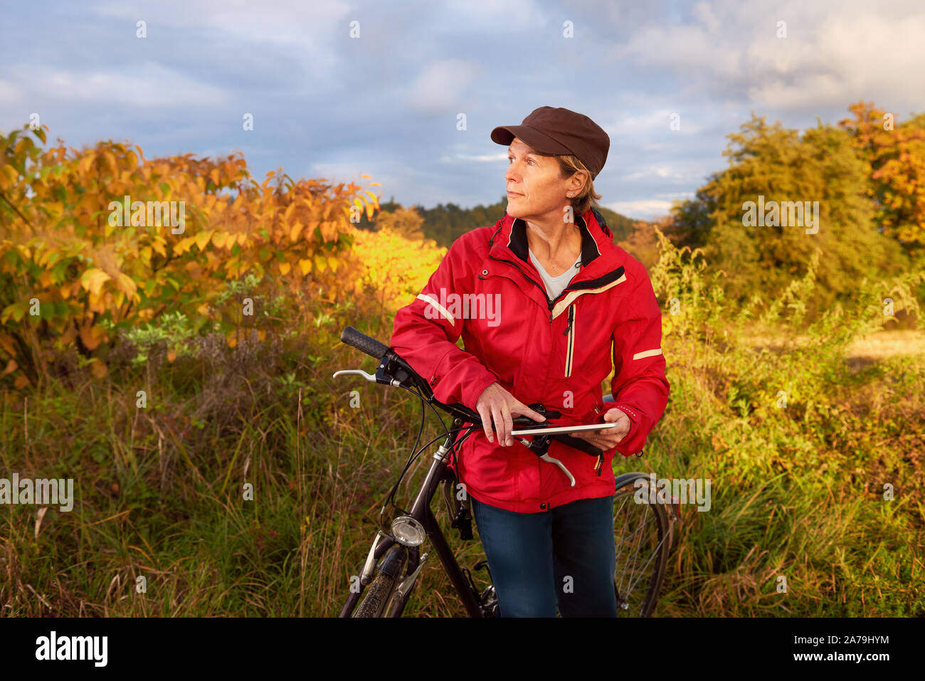 Mittleres Alter weibliche Radfahrer Kontrollen Wetter auf einem Tablet PC-Prognose Stockfoto
