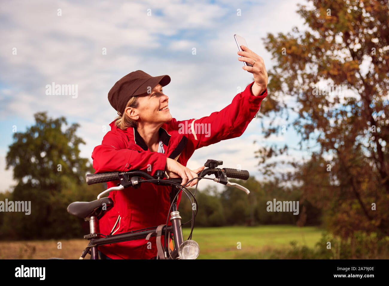 Mittleres Alter weibliche Radfahrer nimmt selfie in der Natur Stockfoto