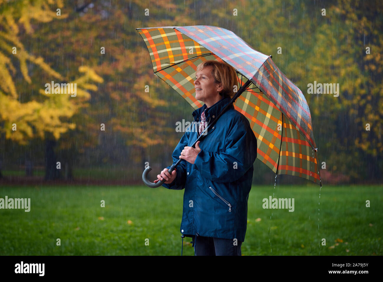 Eine Dame mittleren Alters genießen im Herbst regnerischen Tag im Park Stockfoto