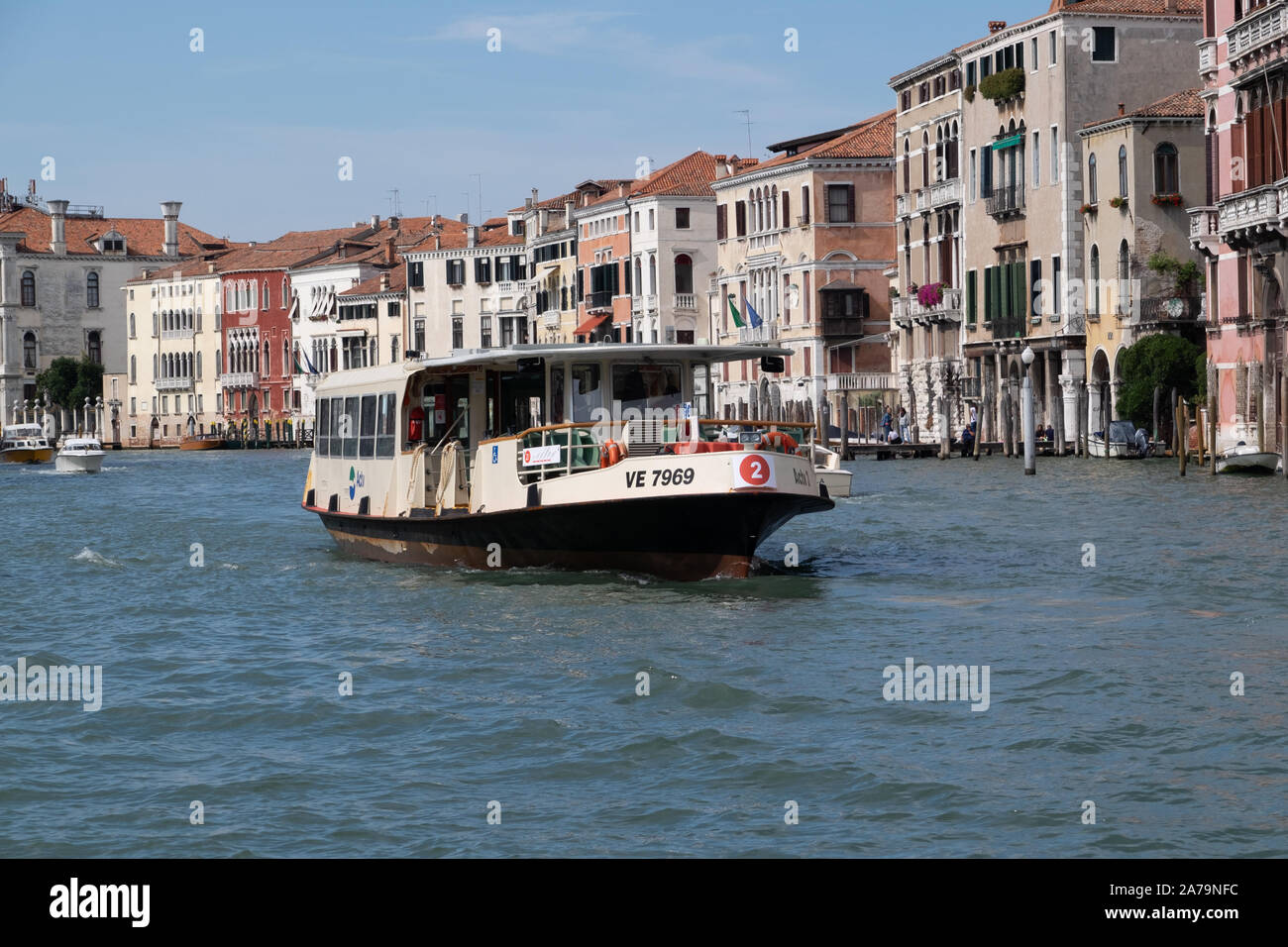 Öffentlicher Verkehr wasser Busse reisen den Canal Grande in Venedig im hellen Sonnenschein mit einem Hintergrund der bunten historischen Gebäude Stockfoto