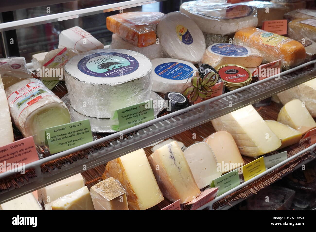 Boothbay Harbor, ME/USA - Oktober 20, 2019: Verschiedene gourmet Käse hinter ein Glas Anzeige zur Abendzeit Spezialitäten Stockfoto