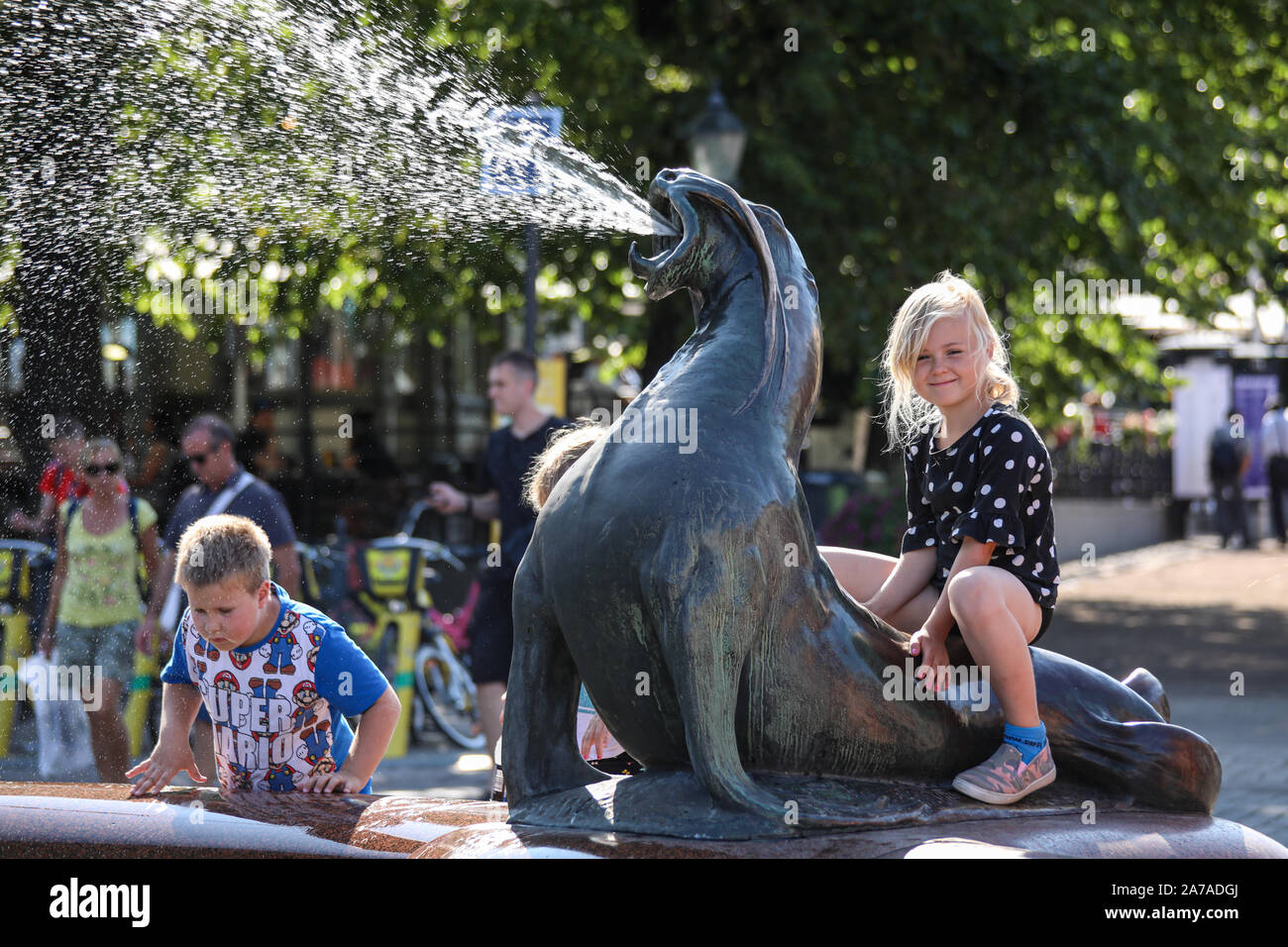 Junge Mädchen auf einem Wasser herausspritzen sea lion Der havis Amanda Statue in Helsinki, Finnland, Stockfoto