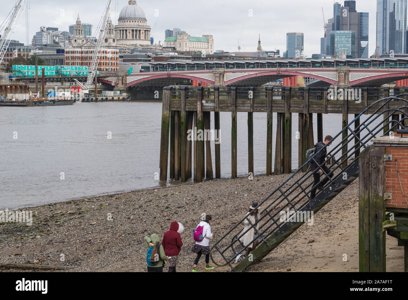 Gruppe von Menschen die Treppen von der Themse vorland an Oxo Tower Wharf, London, England, UK. Der Londoner City und St. Paul's im Hintergrund. Stockfoto