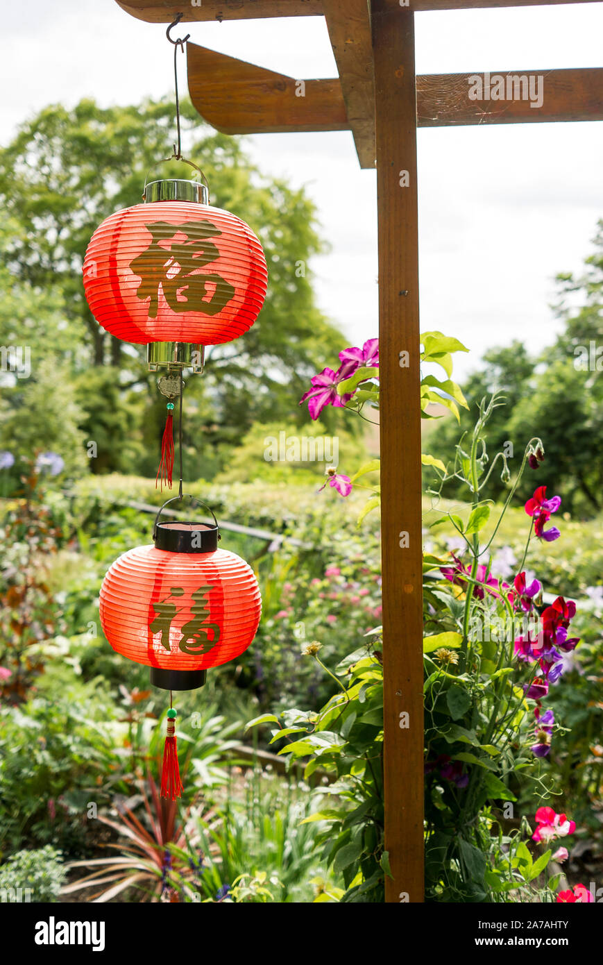 Zwei rote Laternen in einem Englischen Garten im chinesischen Stil in Wiltshire England Großbritannien entwickelt wurde Stockfoto