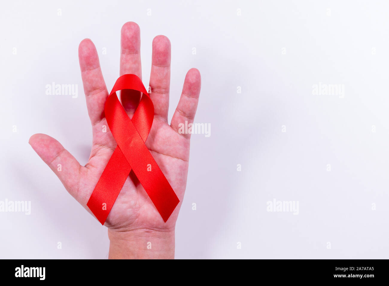 Aids red ribbon auf Hand Unterstützung des Menschen zum Welt-AIDS-Tag. Kopieren Sie Platz. Stockfoto